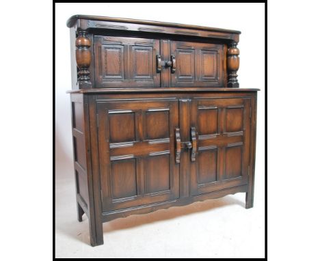 An Ercol Old Colonial / Jacobean revival court cupboard sideboard having upright gallery back with cupboards being raised ove