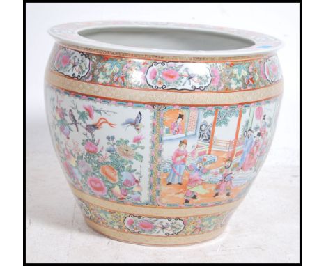 A large Chinese famille rose ceramic carp bowl. Heavily detailed scenes of foliate and vine with scenes of people and places 