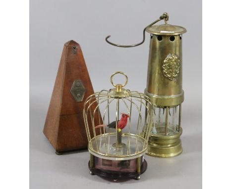 A clockwork automaton formed as a bird in a cage, a brass miners lamp and miniature and a mahogany cased French metronome Mae