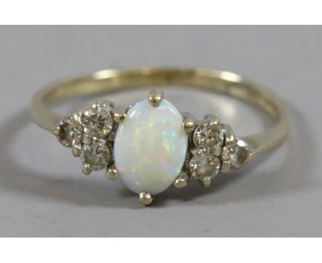 A 9ct gold opal dress ring set with white paste stones, size O.