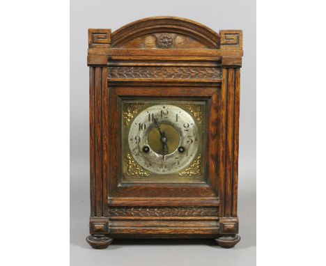 A German oak cased eight day bracket clock with silver chapter ring and housing a Junghans movement.