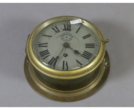 A ships brass bulk head clock with silvered dial and single train movement.