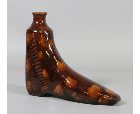 A nineteenth century treacle glazed pottery flask modelled in the form of a boot.