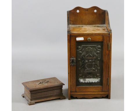 A carved oak smokers cabinet with Art Deco panel to the front and contents of Indian brass tobacco jar with pipe accessories 