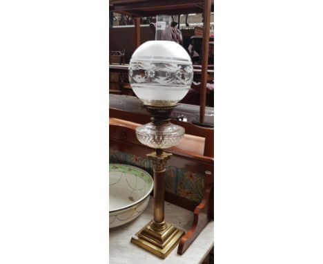 A brass and glass oil lamp with Corinthian column base.Condition:- General wear through age and use, small nibbles to top & b