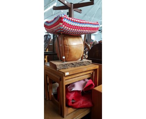 A red cow hide rug, a vintage stool, vintage solid wood table,a leather pouffe  and a teak nest of tables, 