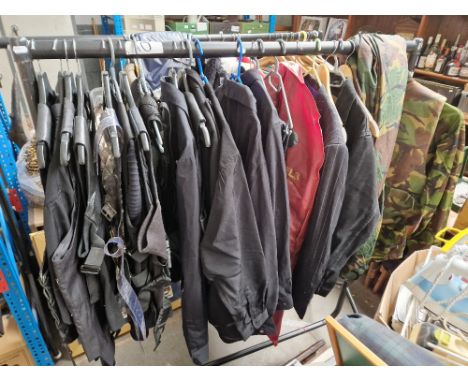 A collection of assorted cosplay items to include camoflage outfit, leather vests, pin stripe suit, combat vest, plated vests