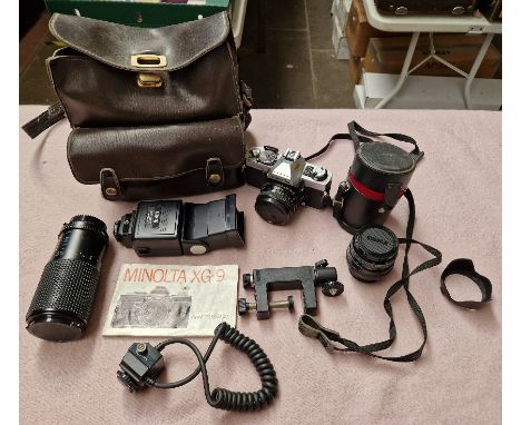 A Minolta 35mm camera with extra lenses and flashgun 