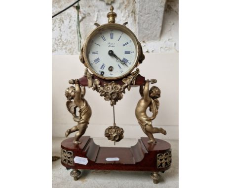A brass mantle clock with cherubs by Rapport, London. 