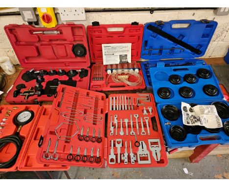 A 15 piece cup oil filter wrench set, a radio removal kit and other tools, mainly unused 