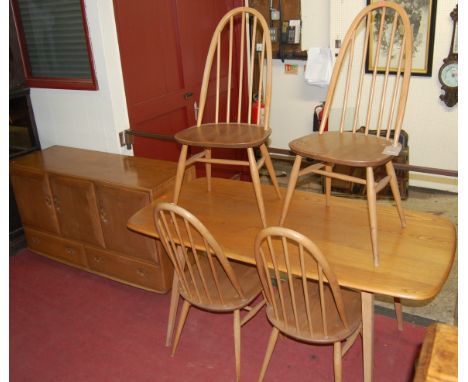 An Ercol blond elm dining suite comprising dining table, four stickback chairs, and a three door sideboard with twin lower dr