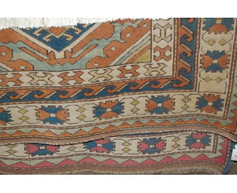 A Turkish woollen rug, having a triple diamond field within multiple trailing borders, 135 x 188cm 
