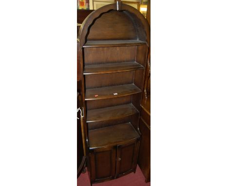 A mid 20th century oak freestanding open bookshelf having bow front double door lower section