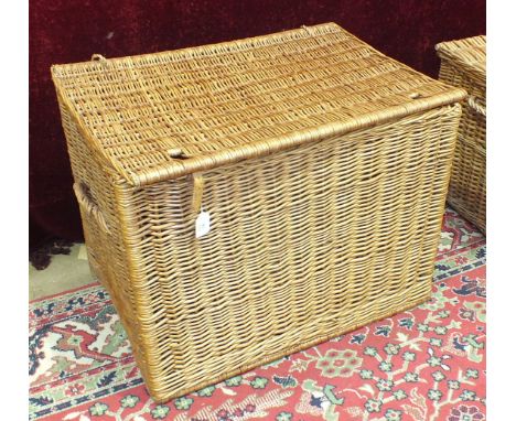 A deep wicker hamper with carrying handles, possibly a log basket, 72cm and other baskets.