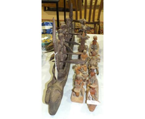 A carved wooden dragon boat group with seven rowing figures holding paddles, 70cm long and other carved wood figures includin