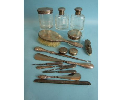 Four silver engine-turned lidded glass dressing table bottles, together with a matching manicure and other dressing table ite