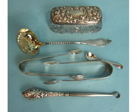 A sifter spoon, Birmingham 1880, a silver-lidded glass dressing table ring box of rectangular shape, two pairs of sugar tongs