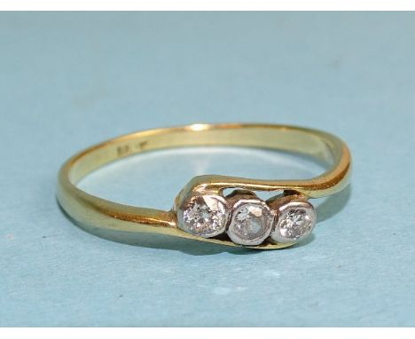 A three-stone diamond crossover ring, the brilliant-cut diamonds collet-set in 18ct gold mount, size N, 1.7g. 