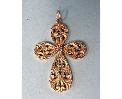 An 18ct yellow gold pendant of stylised cross form, with pierced and engraved decoration centred by a white stone, cross 43 x