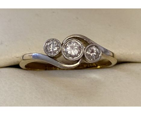 A vintage 18ct and platinum gold twist design bezel set diamond trilogy ring. Approx. total .25ct diamonds. Inside of band ma