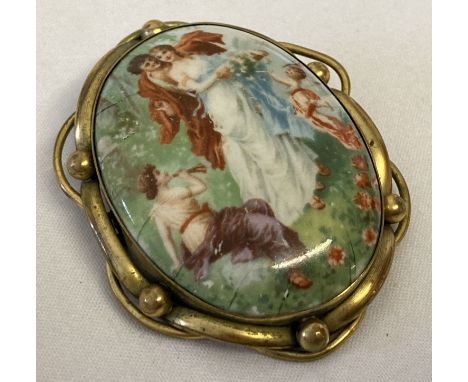 A large vintage pinchbeck mount brooch set with a ceramic panel depicting a courting couple. With small hanging bale to back.