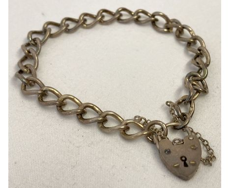 A vintage curb chain charm bracelet with padlock and safety chain. Silver mark to each link. Padlock hallmarked Birmingham 19