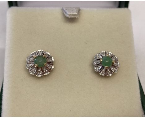 A pair of 9ct gold jade and diamond stud earrings by Luke Stockley, London. Central round cut green jade surrounded by 10 x i