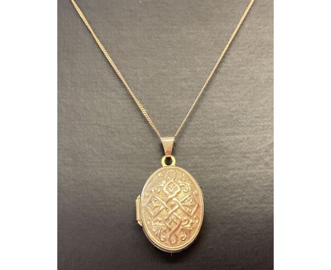 A 9ct gold locket with Celtic design to front on a 18 inch fine curb chain. Locket bale and chain fixings marked 375. Locket 