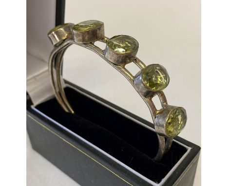 A modern bangle style silver plated bracelet set with 5 large oval cut green stones. Inside marked 925 (mark worn). 