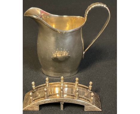 A George V silver helmet shaped cream jug, Nathan &amp; Hayes, Chester 1914; an Oriental silver novelty pepper, as a bridge, 