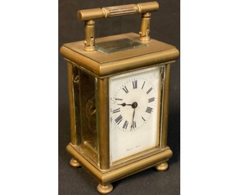 An late 19th/early 20th century French brass carriage timepiece, Roman numerals on white enamel dial, raised on four bun feet