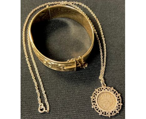 A 9ct gold plated/rolled gold hinged bangle; a George V silver thre'penny bit 1917, mounted in sterling silver as a pendant w