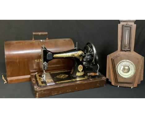 A Singer hand cranked sewing machine; a 1930's oak barometer 