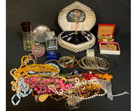 A 1950s/60 musical ballerina manicure set; scent bottles; an enamel hinged bangle; bead necklaces; stone encrusted brooches; 