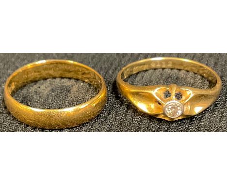 A 22ct gold wedding band, ring size K, 2.9g; an 18ct gold diamond solitaire ring, size L, 2.1g (2) 