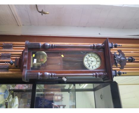 A stained wood Vienna style wall clock, with turned finial surmount, twin train movement striking on a gong, dial with subsid