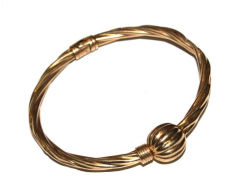 A gold colour sprung loaded bangle (with dent)