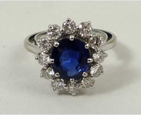 An 18ct gold, sapphire and diamond oval cluster ring, sapphire 3ct, diamonds 0.75ct, size K/L, 4.4g.