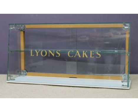 A Lyons Cakes glass display cabinet, with a single glass shelf and white marble base, 76 by 23 by 38cm high. 