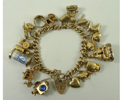 A 9ct gold kerb link charm bracelet with seventeen charms, as fitted, on a heart shaped padlock clasp with safety chain, 91.5