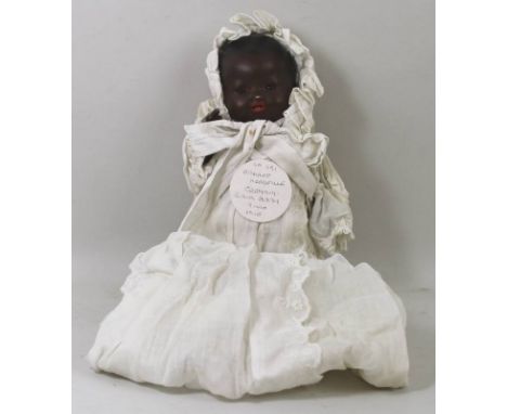 An Armand Marseille black baby doll, with bisque head, fixed brown eyes and wearing a christening gown and bonnet, 1894 AMG/O