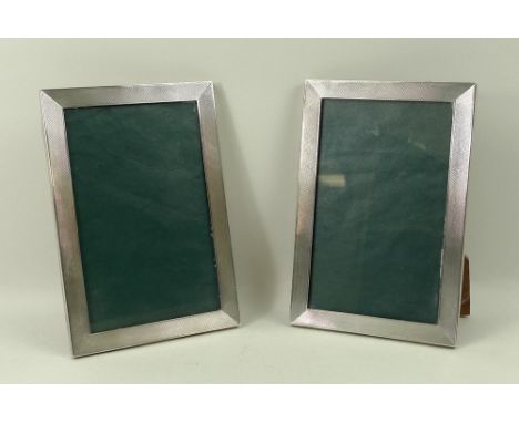 A pair of rectangular silver strut photograph frames with engine turned decoration, Birmingham 1973, 18 by 12cm.
