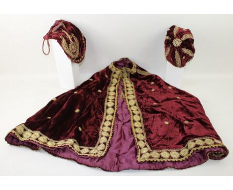 A vintage velvet cape, money bag, and skull cap, the deep burgundy ground richly embroidered in gold threads. 