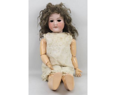 An Armand Marseille doll, the bisque head numbered 390H, with painted wooden articulated limbs, in linen clothes with lace tr