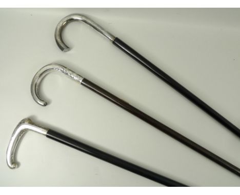 An ebony walking stick with a plated handle embossed with leaves, 90cm, another similar walking stick, 91cm, and a third cane