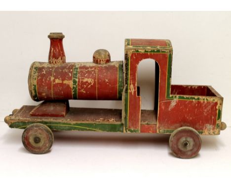A vintage pull along wooden toy train painted in red and green livery, metal cap to cylinder end indistinctly printed with ma