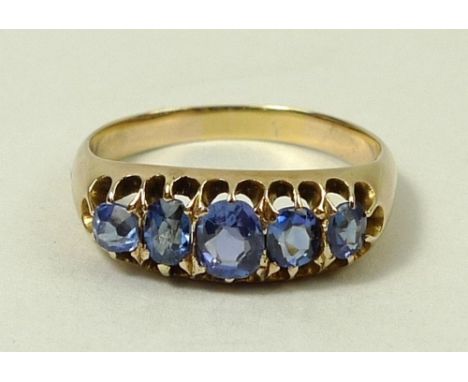 An 18ct gold and blue topaz five stone ring in a claw setting, size R, 4.3g total.