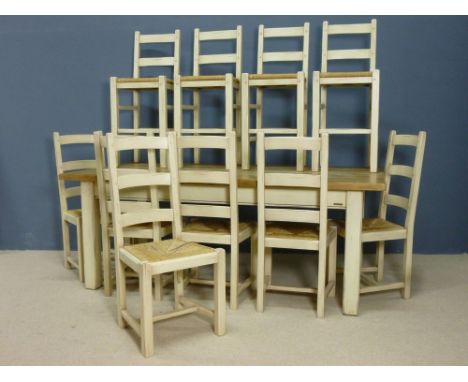 An oak and cream painted farmhouse kitchen table, six rush seated ladder back chairs and a pair of bar stools, 200 by 100 by 