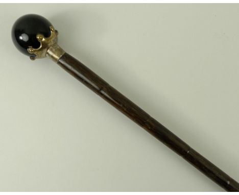 A bamboo walking stick, early 20th century, with a tiger's eye ball knop, in a plated crown mount, 84cm long.