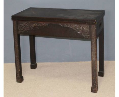 A Chinese hardwood fold over card table, carved in bas relief raised on square legs, bears label for 'George Zee & Co, Kowloo